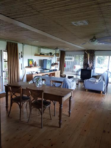ein Wohnzimmer mit einem Holztisch und Stühlen in der Unterkunft Piedra De Agua Chacra, casa, piscina, bosque, río. in Minas