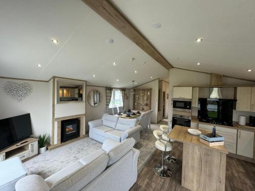 a living room with white furniture and a fireplace at Golden Anchor - The Oakland Lodge - Coastal Caravan Breaks in Chapel Saint Leonards