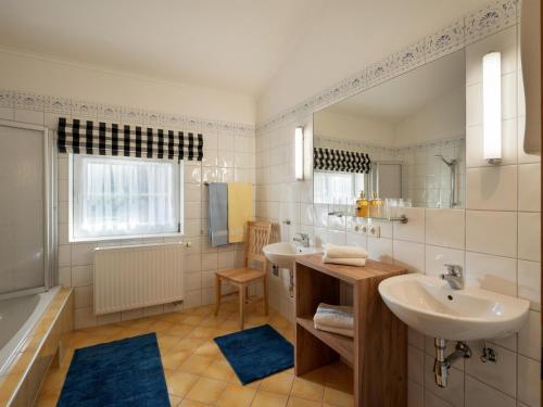 a bathroom with two sinks and a tub at Appartement Hintermitterast in Kirchberg in Tirol