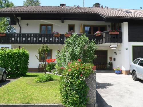 a house with a balcony with flowers on it at Gästehaus Gaisalpe in Fischen