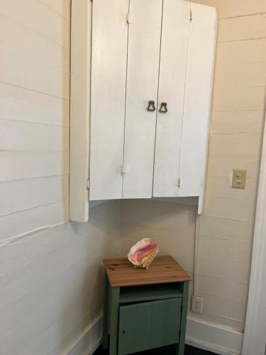 a kitchen with a table and white cabinets at Downtown Nassau Oasis Unit 2 in Nassau