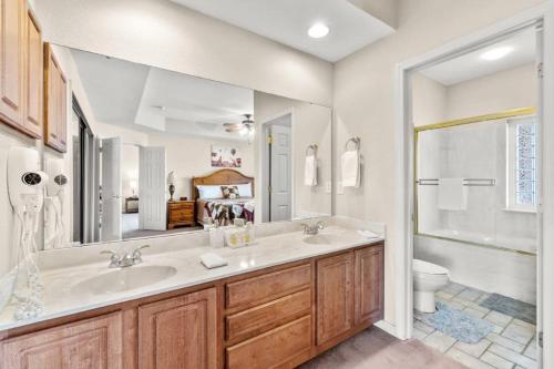 a bathroom with a sink and a toilet and a mirror at Branson Condo at Thousand Hills Walkin with Elevator Golf Front and close to 76 in Branson