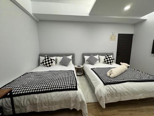a bedroom with two beds with a teddy bear on them at 漫光時旅民宿-電子入住 in Taitung City