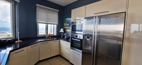 een keuken met een roestvrijstalen koelkast en een wastafel bij Apartment Royal Palm Resort in Willemstad