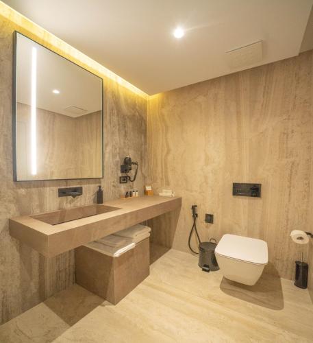 a bathroom with a sink and a toilet and a mirror at ALYACHT Premium Hotel in Sarandë