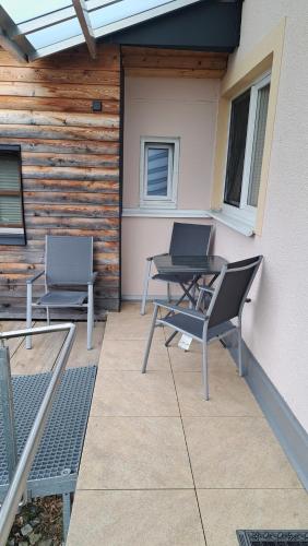 2 sillas y una mesa en el patio en Monte Baldo, en Ilmmünster