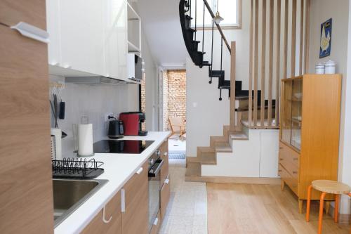 a kitchen with white countertops and a staircase at Villa Juliette - Plage et falaises en famille in Le Tréport
