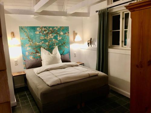 1 dormitorio con 1 cama con una pintura en la pared en Gästehaus Altes Forstamt Sinntal en Sinntal