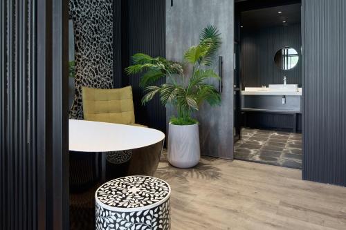 a bathroom with a white table and a plant at Cargo88 Hotel in Lusaka