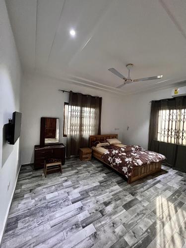 a bedroom with a bed and a tv in a room at Lovely 5-Bed House Getaway Duplex in Accra in Accra