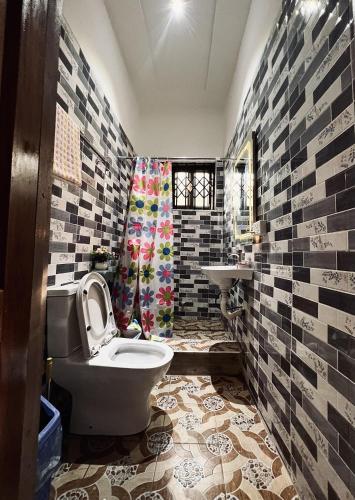 a bathroom with a toilet and a sink at Lovely 5-Bed House Getaway Duplex in Accra in Accra