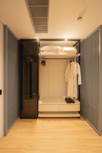 a walk in closet with a white shirt on a rack at ALYACHT Premium Hotel in Sarandë