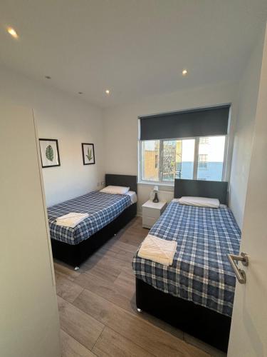 1 dormitorio con 2 camas y ventana en Access Euston, en Londres
