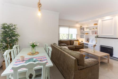a kitchen and living room with a table and chairs at San Miguel 34 Rooms in Málaga