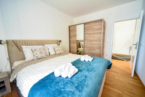 ein Schlafzimmer mit einem Bett mit Handtüchern auf einer blauen Decke in der Unterkunft BAGDALA RESIDENCE APARTMAN in Kruševac