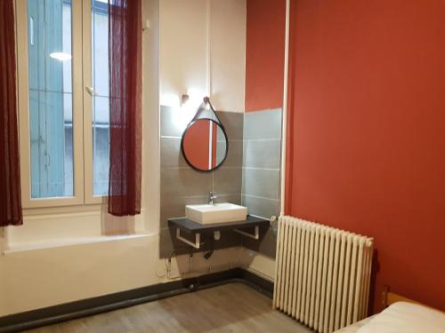 uma casa de banho com um lavatório, um espelho e uma banheira em Le Rochereau YourHostHelper em Grenoble