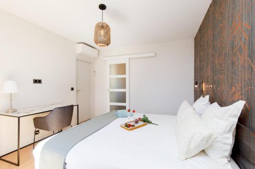une chambre avec un lit blanc et un bureau dans l'établissement 06AG - Bel appartement proche Palais des Festivals, à Cannes