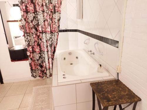 a bath tub in a bathroom with a shower curtain at Hotel Spazio in Ivoti