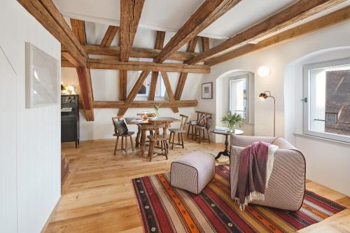 a living room with wooden ceilings and a table and chairs at Engelwirt Hotel & Apartments in Berching