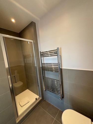 a bathroom with a glass shower and a toilet at Access Euston in London
