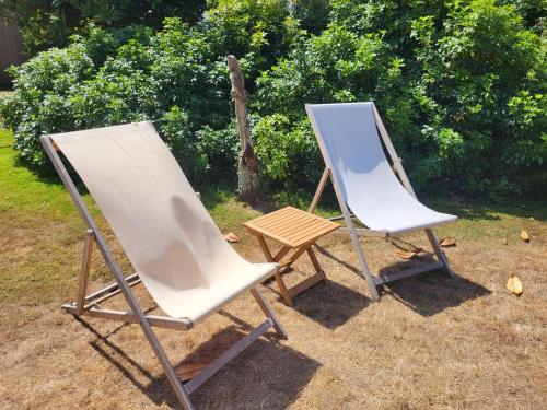 two folding chairs and an easel next to a painting at Unique & Rural Child Friendly Annexe with Large Gardens, Games & Tennis Court - Chichester Holiday Properties in Chichester