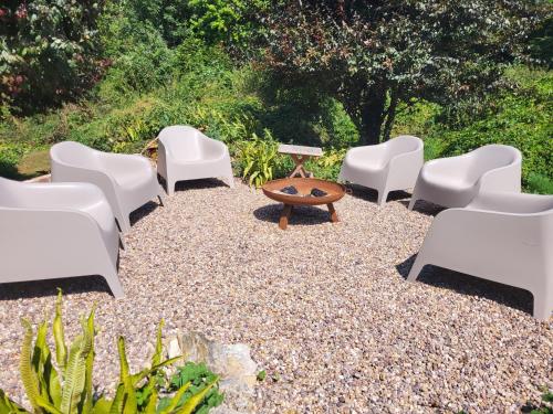a group of chairs and a table on a gravel patio at Unique & Rural Child Friendly Annexe with Large Gardens, Games & Tennis Court - Chichester Holiday Properties in Chichester