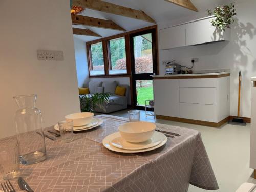 a kitchen with a table with plates on it at Unique & Rural Child Friendly Annexe with Large Gardens, Games & Tennis Court - Chichester Holiday Properties in Chichester