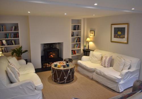 un soggiorno con 2 divani bianchi e un camino di West Pallant Georgian Townhouse in City Centre with Courtyards, BBQ & Log Burners - Dogs Welcome! Chichester Holiday Properties a Chichester