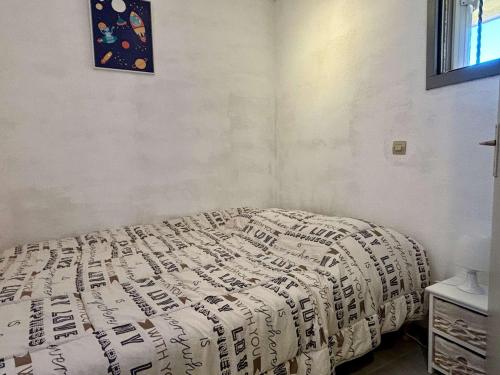 sypialnia z łóżkiem z kocem w obiekcie Studio cabine à 400m de la mer avec piscines, parking privé et loggia - Argelès-sur-Mer - FR-1-225-768 w Argelès-sur-Mer