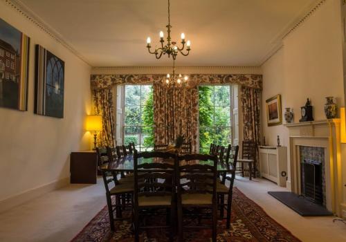 奇切斯特的住宿－Large 8 Bedroom Georgian House in Central Chichester with Parking - Great for Celebrations!，一间带桌椅和壁炉的用餐室