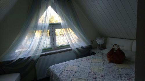 a bedroom with a bed and a window with a purse on it at Ferienhaus Rose & Lavendel in Zühlsdorf