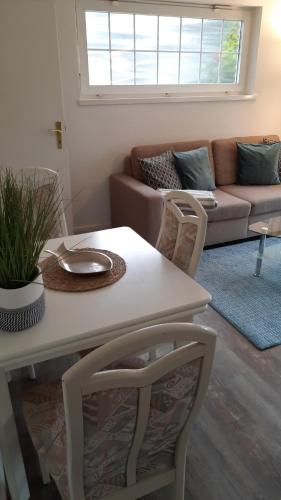uma sala de estar com uma mesa e cadeiras e um sofá em Gästehaus Wendland - Timmendorfer Strand em Timmendorfer Strand