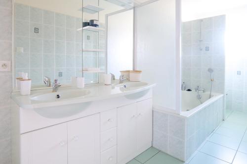une salle de bain avec deux lavabos, une baignoire et un miroir dans l'établissement Maison proche côte sauvage, La Chaume - 7 personnes, à Les Sables-dʼOlonne