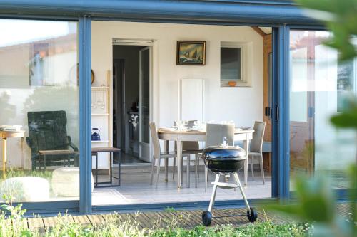 une extension en verre d'une maison avec un grill dans l'établissement Maison proche côte sauvage, La Chaume - 7 personnes, à Les Sables-dʼOlonne