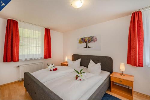 コルスヴァントにあるWaldsiedlung Waldhaus App 4.1のベッドルーム1室(花2本のベッド1台付)