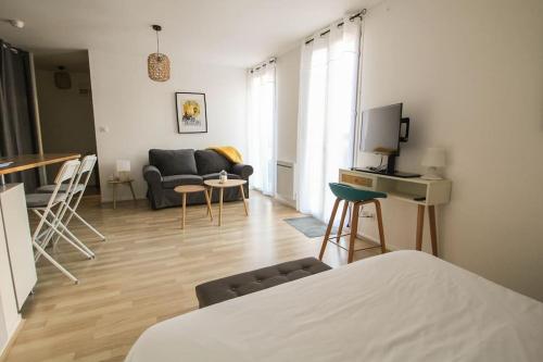a living room with a couch and a table at Le St Ausone : Studio Centre Ville/parking in Angoulême