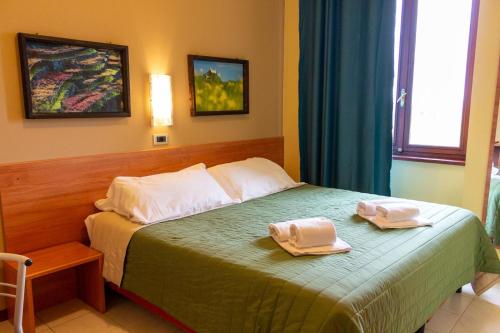 a bedroom with a bed with two towels on it at Hotel Erbaluce in Caluso