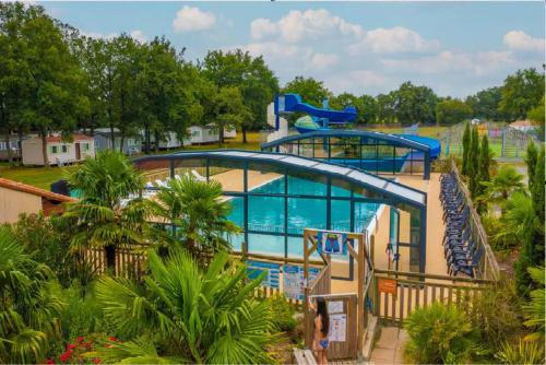 a large swimming pool in a resort with two slides at Mobil Home 3 chambres 6 pers 1/2h PUY du FOU in La Boissière-de-Montaigu