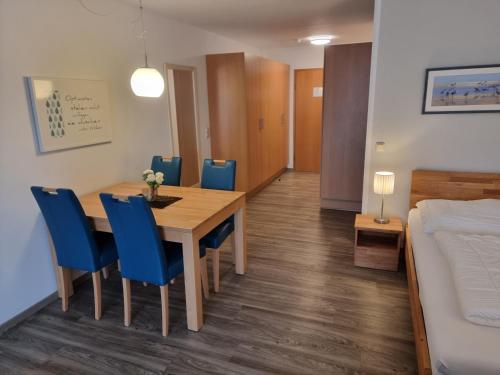 - une salle à manger avec une table, des chaises et un lit dans l'établissement Steiner Strandappartements Appartement 106 Süd- Landseite, à Stein