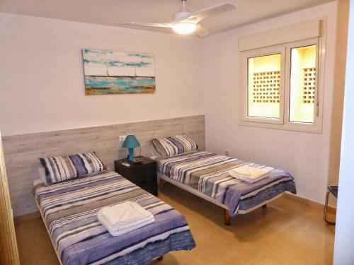 two beds in a room with two windows at Mar Menor Golf 2 Free Pool, Padel tennis, Gym Yoga etc in Murcia