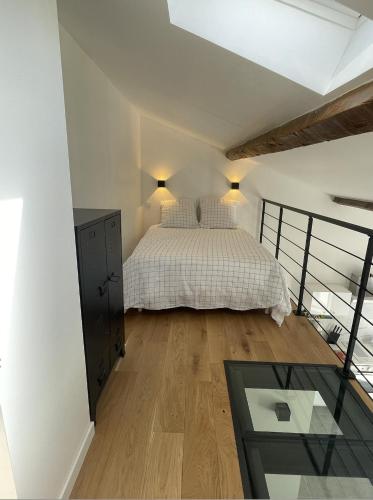 une chambre avec un lit et une table en verre dans l'établissement Petite Maison à la Loubiere avec jardin, clim et parking, à Toulon