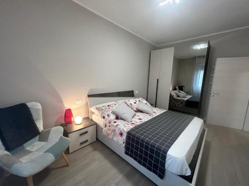 um quarto com uma cama, uma cadeira e um espelho em Casa Ari em Desenzano del Garda