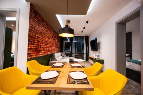 a dining room with a table and yellow chairs at DMS Apartments & Suites Sarajevo in Vogošća