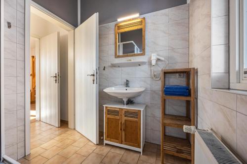 ein Bad mit einem Waschbecken und einem Spiegel in der Unterkunft Seeadler 11 in Buchholz