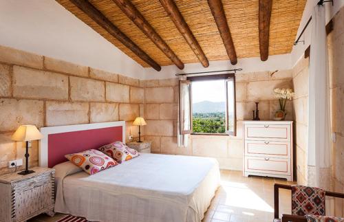 Un dormitorio con una cama grande y una ventana en Sa Fontasa, en Moscari