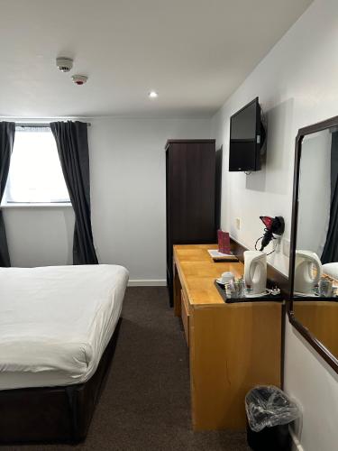 a hotel room with a bed and a mirror at Ramada Birmingham Oldbury M5 J2 in Oldbury