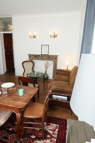 a living room with a table and a couch at Appartements 4 vents by La Boîte En Plus in Senlis