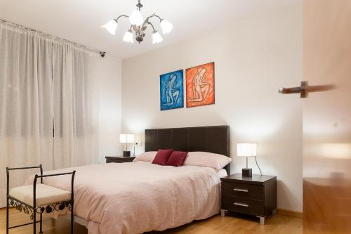 a bedroom with a bed and two tables and a chair at AndBnB I 3 Habitaciones con Terraza y Parking in Ordino