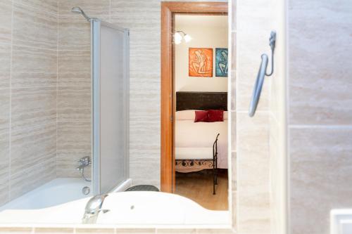 a bathroom with a tub and a sink and a mirror at AndBnB I 3 Habitaciones con Terraza y Parking in Ordino