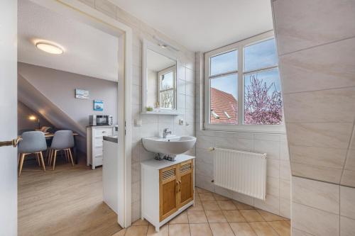 een badkamer met een wastafel en een raam bij Kranichhorst 7 in Buchholz